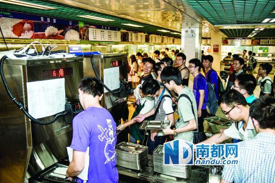 昨日，華南理工大學一食堂內，學生們正在使用新安裝的自動打飯機打飯。中新社發(fā)
