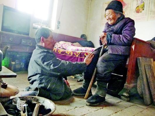 52歲的劉蘭山每天靠爬行照顧90歲的老母親。孫國祥 攝