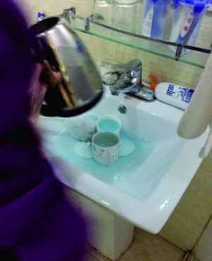 酒店服務(wù)員用潔廁液刷燒水壺和茶杯。