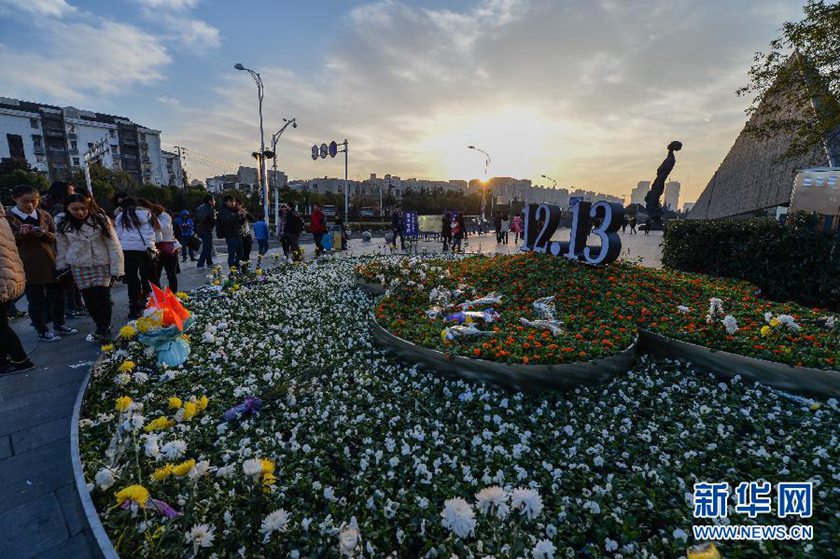 12月14日,觀眾在侵華日軍南京大屠殺遇難同胞紀(jì)念館前的“12·13”花壇上擺放鮮花祭奠遇難同胞。新華社記者 沈鵬 攝