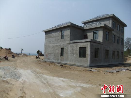 鴨河水庫(kù)庫(kù)區(qū)邊的新建別墅，一面墻上寫著“拆”，另一邊在加緊施工。吳揚(yáng)　攝