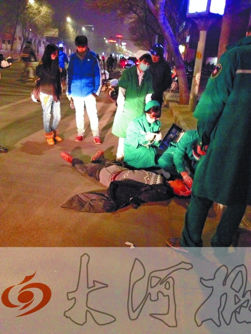 醉漢躺在地上，醫(yī)護(hù)人員對其進(jìn)行檢查。